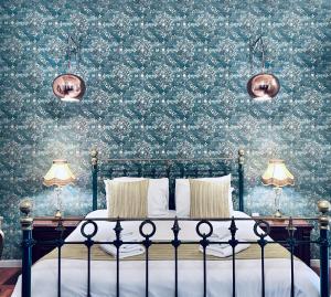 ein Schlafzimmer mit einem Bett mit geblümter Tapete in der Unterkunft Casa Birmula Boutique Hotel in Cospicua