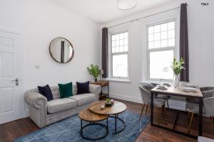 a living room with a couch and a table at 1 Bed Apartments, 2 Mins to Beach, Sleeps 4 in Southend-on-Sea