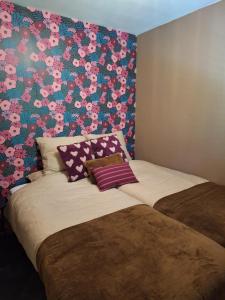 a bedroom with two beds with a floral wall at Boshuisje Het Bosnest - de Specht bungalow met privétuin op Hoefbos Otterlo Veluwe in Otterlo