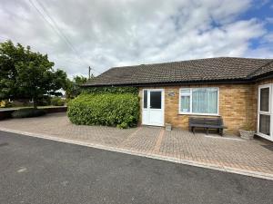 a brick house with a bench in front of it at Dainville Lodge in Skegness