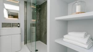une salle de bain avec une douche en verre et des serviettes blanches dans l'établissement 3 Beach Terrace, à Rhosneigr 82 autres photos