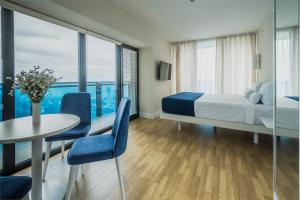 a bedroom with a bed and a table and chairs at Апарт-отель в Панорама Бич in Batumi +39 photos