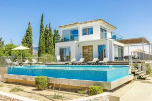 a villa with a swimming pool in front of a house at Villa Katrina in Svoronata