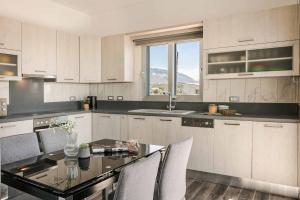 a kitchen with a table and chairs and a window at Villa Katrina in Svoronata