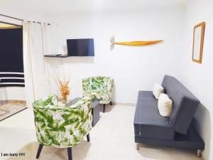 ein Wohnzimmer mit zwei Stühlen und einer Couch in der Unterkunft apartamento con vista al mar y centro histórico in Cartagena de Indias