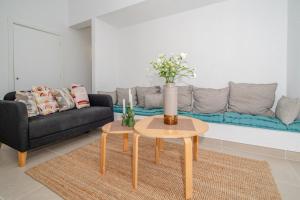 una sala de estar con una mesa y un sofá en Newly refurbished bungalow in prime location, en Playa de las Américas