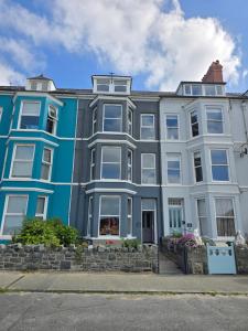 a large blue and white building on a street at Seashell Apartment in Barmouth +17 photos