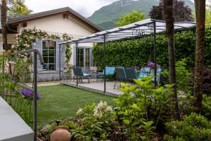 a garden with a pergola and a table and chairs at Maji Como Lake in Mandello del Lario