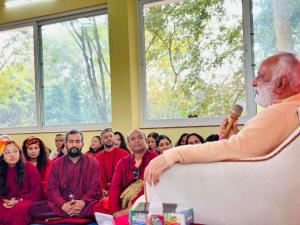 a man speaking to a group of people in a room at OSHO Jetban Spiritual Village, Lumbini in Lumbini
