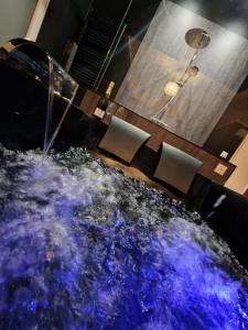 a dining room with a blue table and chairs at Suite romantique avec Balneo et jeux coquins in Roanne