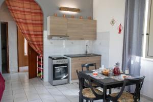 a kitchen with a table and a stove top oven at La panchina in Noto