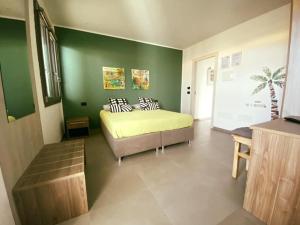 a bedroom with a bed and a green wall at Solus b&b in Casteldaccia