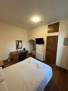 a bedroom with a large white bed and a desk at Royal Britannia Hotel in Ilfracombe