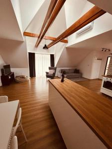 kuchnia i salon z drewnianymi podłogami i sufitami w obiekcie Pataky Apartmanok w mieście Veszprém