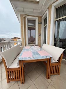 a table and two chairs on a balcony at Тематичен Пентхаус Несебър България in Nesebar