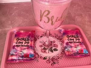 a pink tray with a wine glass and some snacks at Тематичен Пентхаус Несебър България in Nesebar