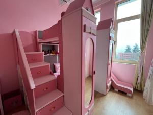 una camera da letto rosa con un letto a castello e scale di Тематичен Пентхаус Несебър България a Nesebar Altre 46 foto