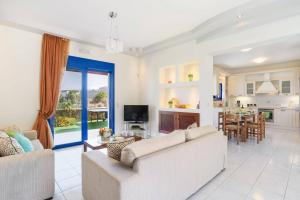 ein Wohnzimmer mit 2 Sofas und einer Küche in der Unterkunft Villa Matina by Villa Plus in Lindos