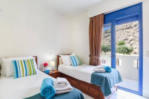 ein Schlafzimmer mit zwei Betten mit Handtüchern darauf in der Unterkunft Villa Matina by Villa Plus in Lindos