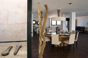 a dining room with a wooden table and white chairs at Hospedium Hotel Convento de Santa Ana in Atienza