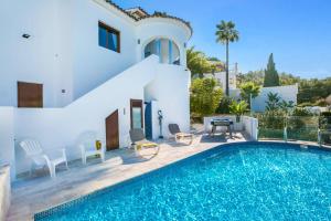 a villa with a swimming pool and a house at Villa Kmar by Villa Plus in Cumbre del Sol