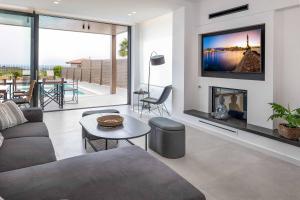 Una sala de estar con chimenea y televisión. en Kamelia Villa 3, en Hersonissos