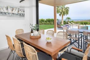 Un comedor con mesa y sillas de madera. en Kamelia Villa 3, en Hersonissos