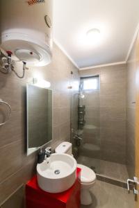 a bathroom with a sink and a toilet and a shower at Odeio UpTown urban stay studio in Patra +20 photos