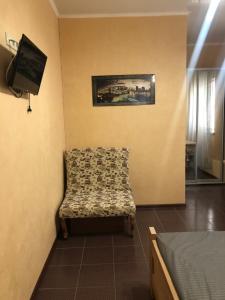 a room with a chair and a tv and a bed at Людмила in Chornomorsk