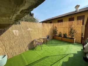 a backyard with chairs and a table and a fence at Lakefront Apartment with Panoramic Pool in Ranzanico