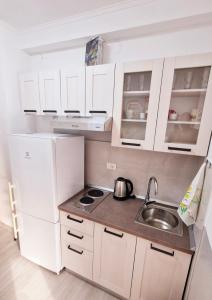 a small kitchen with white cabinets and a sink at Apartmani Deniza 2 guests in Brodarica