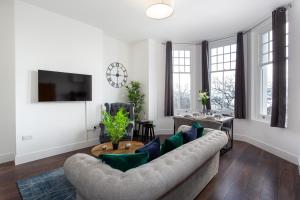 a living room with a couch and a tv at 1 Bed Apartments, 2 Mins to Beach, Sleeps 4 in Southend-on-Sea