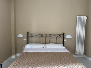 a bedroom with a large bed with white sheets and a radiator at Dimora in Costiera Amalfitana in Maiori