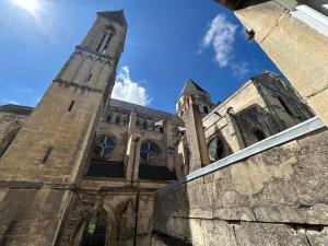 a large building with a tower and a clock at Le Petit Guillaume in Caen