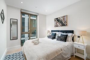 Una cama o camas en una habitación de Battersea 2BR Flat - Gym, Balcony, Parking, Great Location - Long Stays Welcome