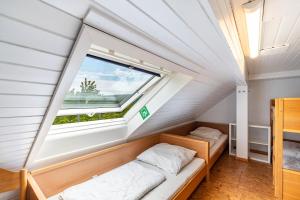 a room with two beds and a window at Naturerlebnishaus Gaistal in Bad Herrenalb
