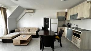 a kitchen and a living room with a couch and a table at Двустаен апартамент in Ahtopol