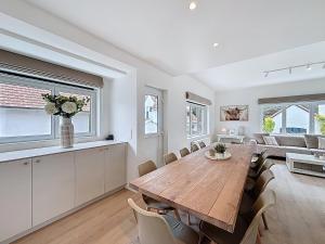 Una sala de estar con una mesa y sillas de madera. en Villa Strada - Koksijde, en Koksijde