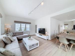 una sala de estar con un sofá y una mesa en Villa Strada - Koksijde, en Koksijde