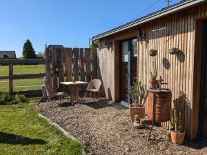 a patio with a table and chairs next to a building at chambre du Saussay in Villers-Écalles