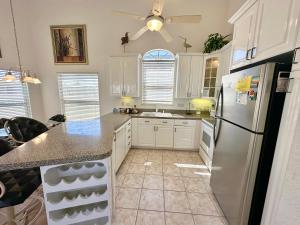 a kitchen with white cabinets and a refrigerator at Bluewater Haven in Jensen Beach