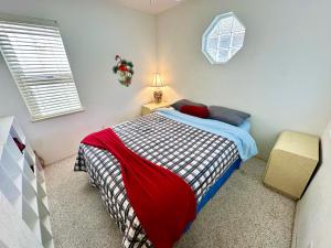 a bedroom with a bed with a red and blue blanket at Bluewater Haven in Jensen Beach +28 photos