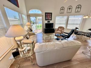 a living room with a white couch and chairs at Bluewater Haven in Jensen Beach