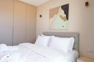 a bedroom with a bed with white pillows and a painting at Casa Olea Apart Hotel in Çeşme +53 photos