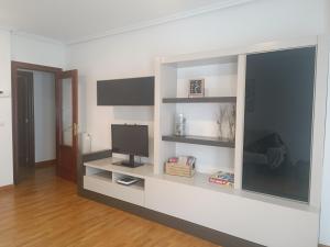a living room with a tv on a white wall at Apartamento San Pelayo, LA PICUDA in San Vicente de la Sonsierra