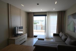 a living room with a couch and a television at Casa Olea Apart Hotel in Çeşme