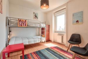 a bedroom with bunk beds and a table and chairs at Maison pour 8 dans le centre de Plouguerneau in Plouguerneau