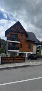 a wooden house with a car parked in front of it at Zen Retreat Apartment in Sinaia