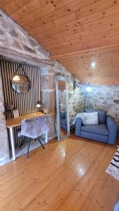 a living room with a blue couch and a mirror at O lar de Cabanas in Brion