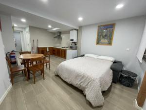 a bedroom with a bed and a table and a kitchen at erdiko kalea 9 in Marquina-Jemein